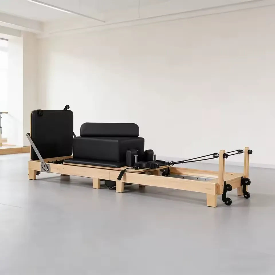 Reformer Pilates PIEGA en bois installé dans une pièce lumineuse