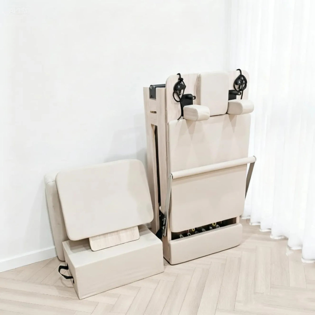 Reformer Pilates PIEGA en bois plié avec ses accessoires à proximité